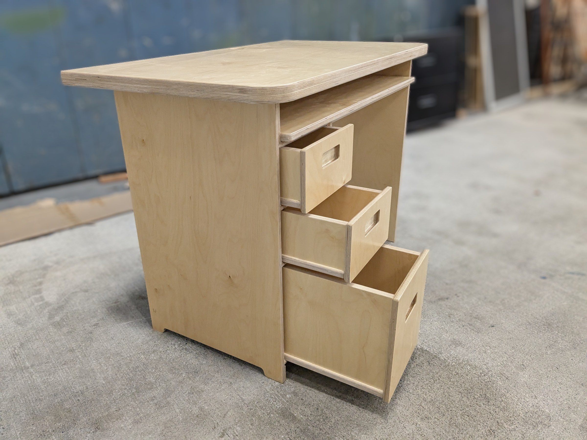 Wood drawers of different sizes partially open in a desk